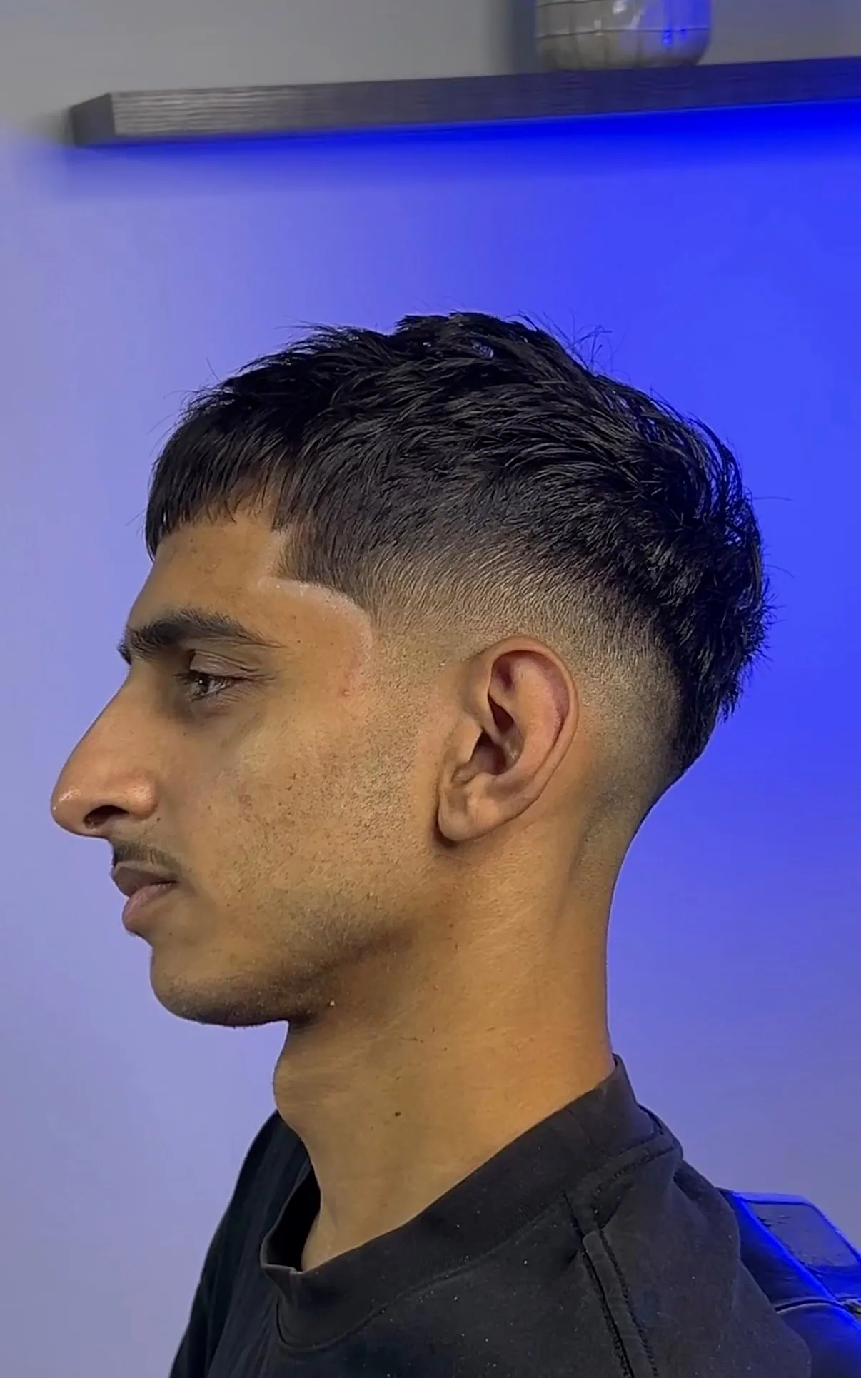 Choppy textured crop with the fringe cut square, over a drop fade taken tight behind the ear.